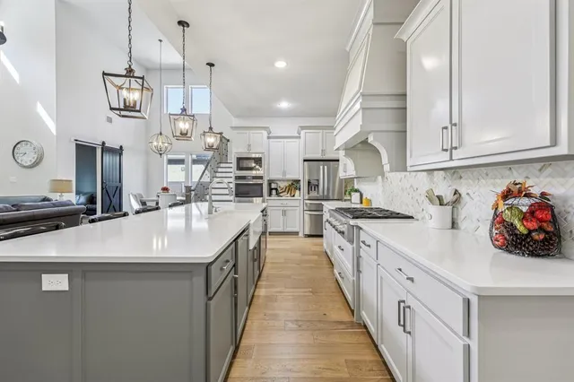 a kitchen with kitchen island a sink appliances and cabinets