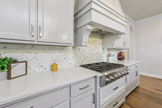 a kitchen with white cabinets and a stove
