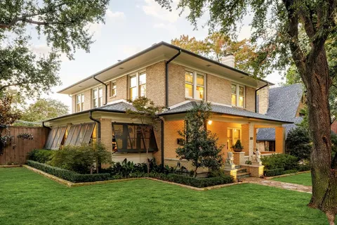 a front view of a house with a garden and plants