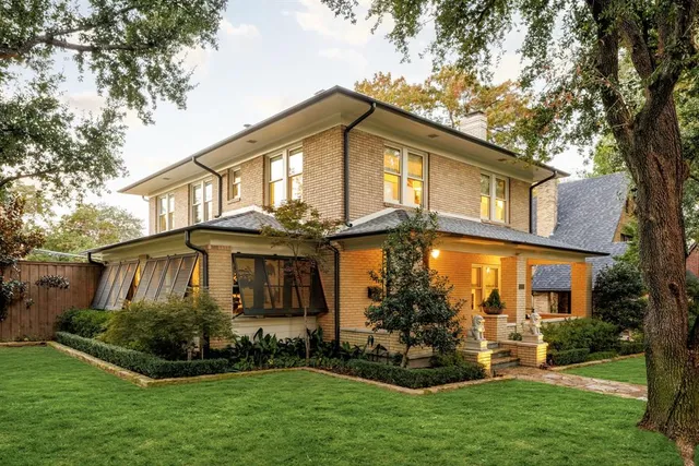 a front view of a house with a garden and plants
