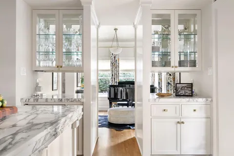 a kitchen with kitchen island granite countertop a sink and a view of living room