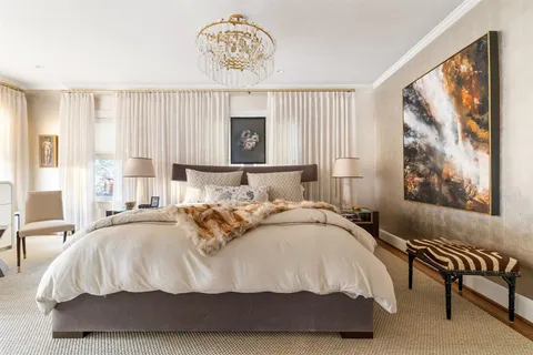 a bedroom with a bed and a painting on the wall