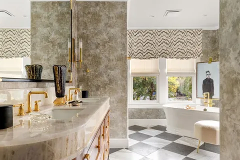 a bathroom with a double vanity sink mirror and bathtub