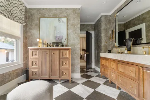 a spacious bathroom with a double vanity sink a mirror a bathtub and next to a window