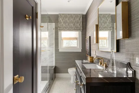 a bathroom with a granite countertop sink a toilet and shower
