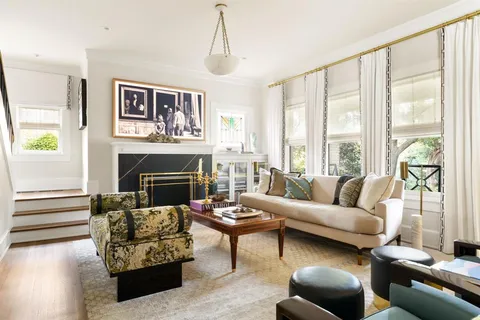 a living room with furniture a large window and a fireplace