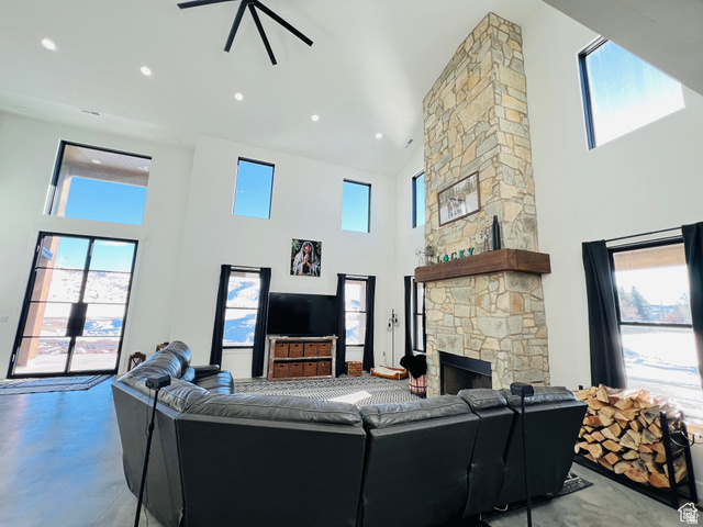 100 Whit Lane Georgetown, ID 83239 - Photo 17 of 76 Living room featuring a high ceiling, finished concrete floors, ceiling fan, and a stone fireplace
