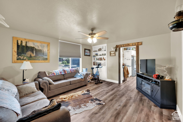 1632 South Main Street Springville, UT 84663 - Photo 2 of 93 Living area featuring wood finished floors, a ceiling fan, built in features, and a textured ceiling