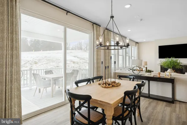 a dining room with furniture window and wooden floor
