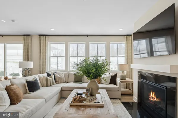 a living room with furniture a large window and a fireplace
