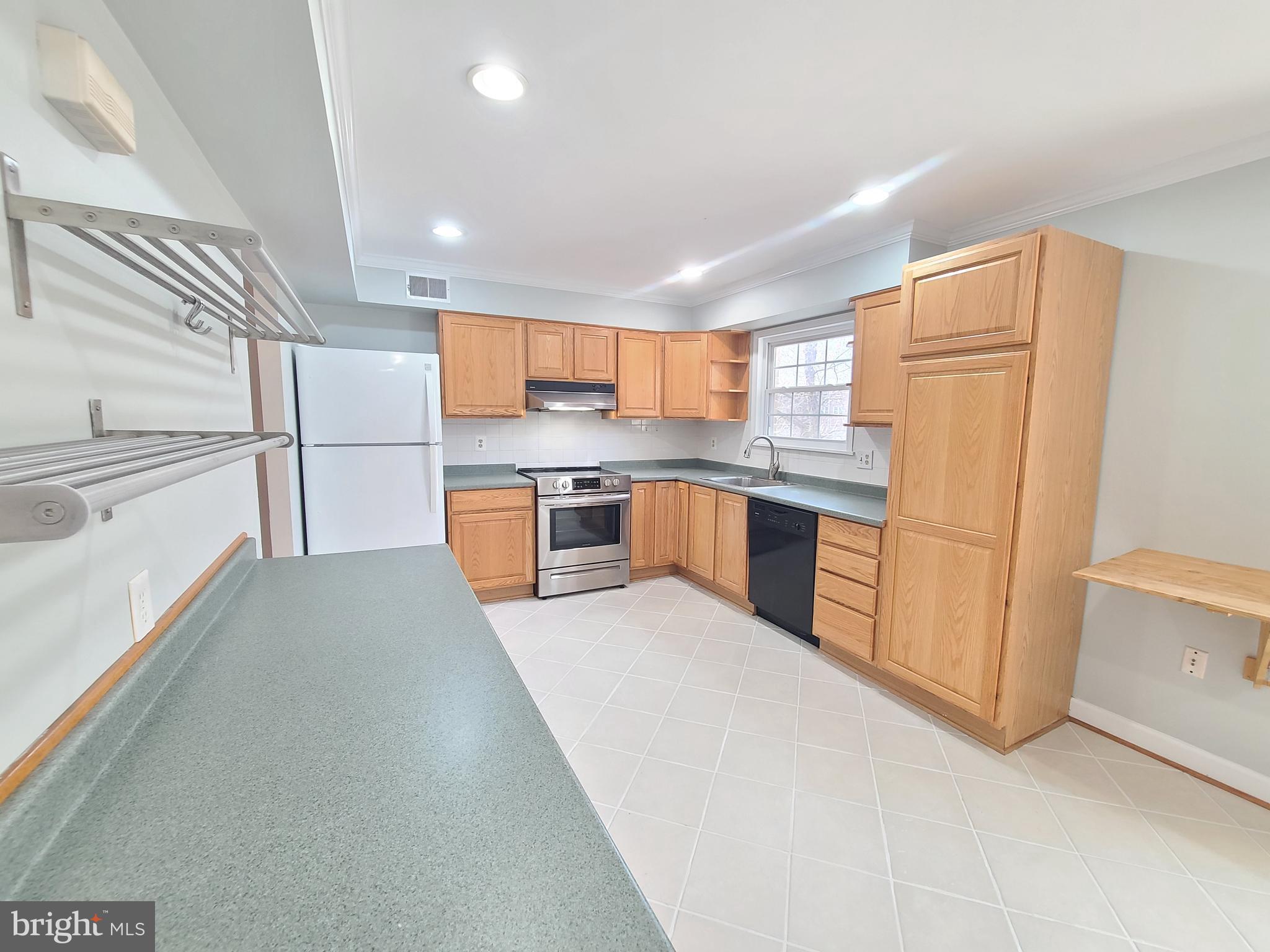 6644 Green Ash Drive Springfield, VA 22152 - Photo 13 of 42 a kitchen with stainless steel appliances a refrigerator a stove a sink and white cabinets
