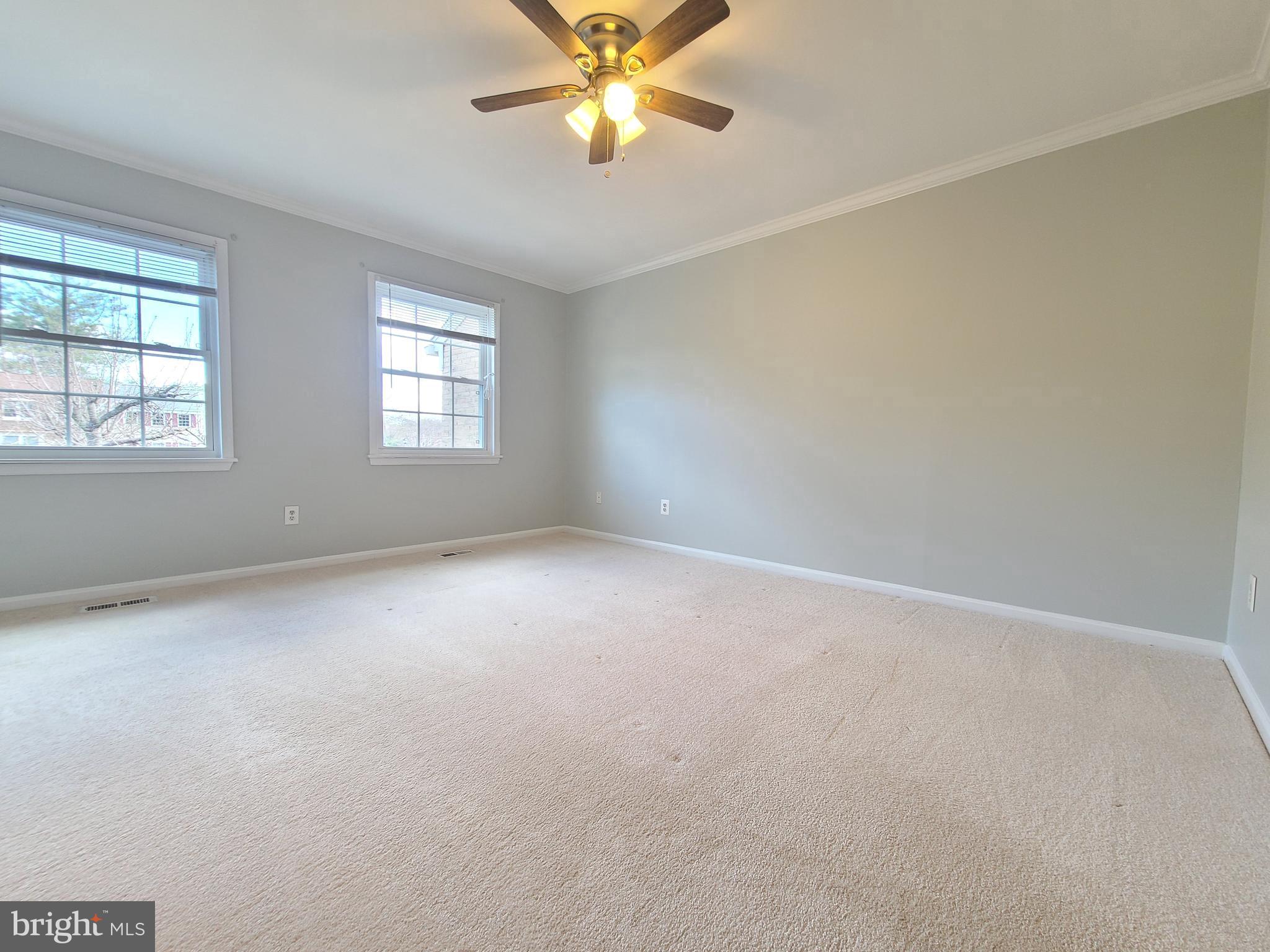 6644 Green Ash Drive Springfield, VA 22152 - Photo 19 of 42 an empty room with windows and chandelier fan