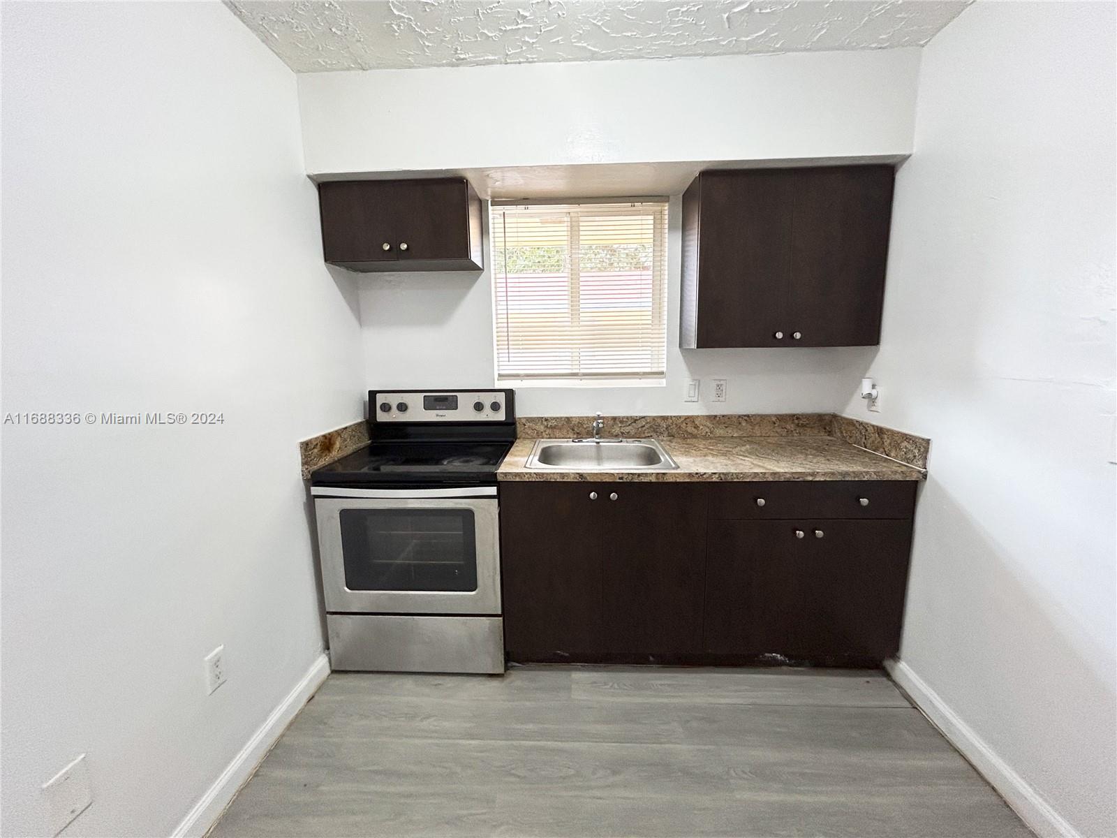 651 Northeast 86th Street, Unit 3 Miami, FL 33138 - Photo 1 of 11 a kitchen with a stove and a microwave