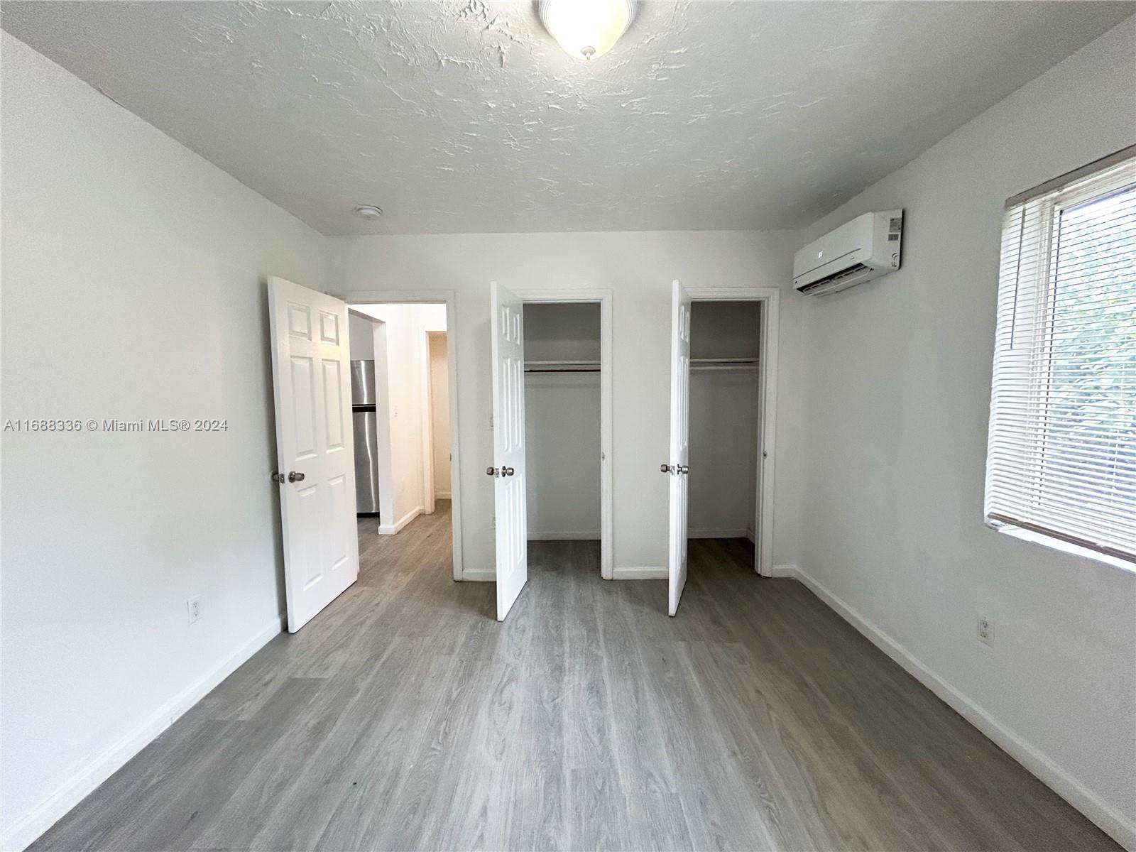 651 Northeast 86th Street, Unit 3 Miami, FL 33138 - Photo 11 of 11 wooden floor in an empty room with a window
