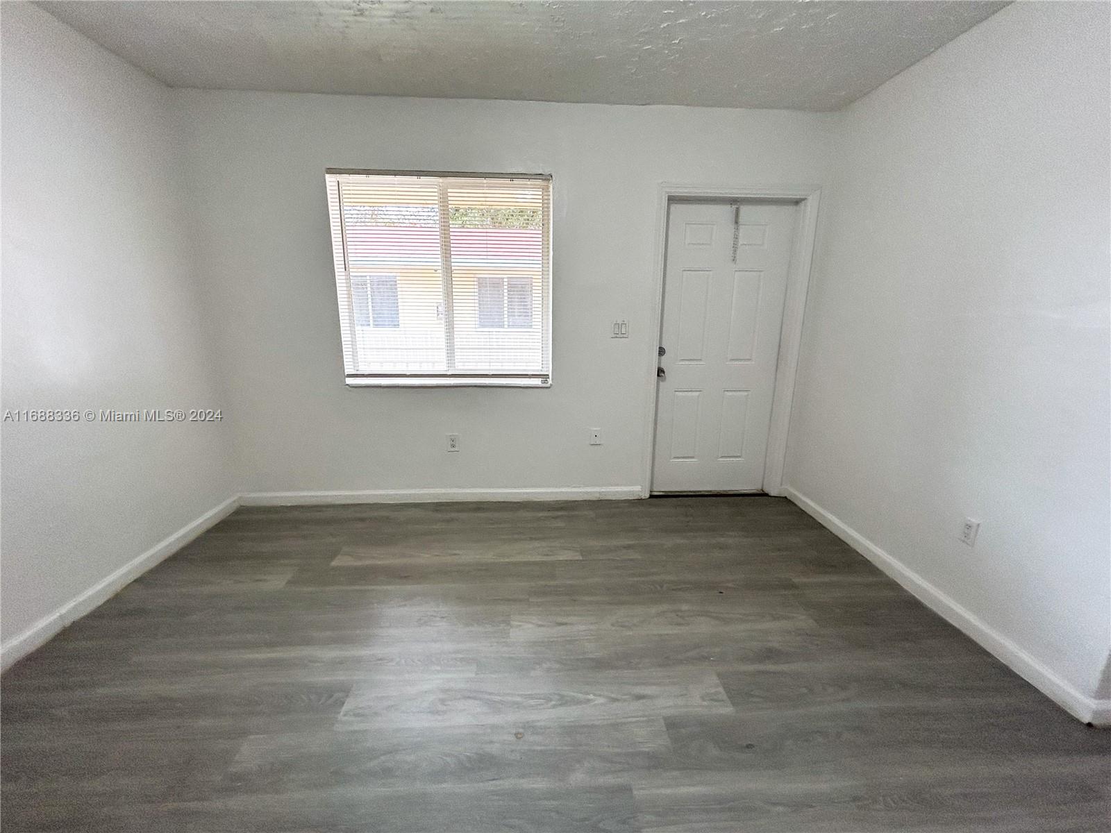 651 Northeast 86th Street, Unit 3 Miami, FL 33138 - Photo 6 of 11 a view of a room that has wooden floor and window in it