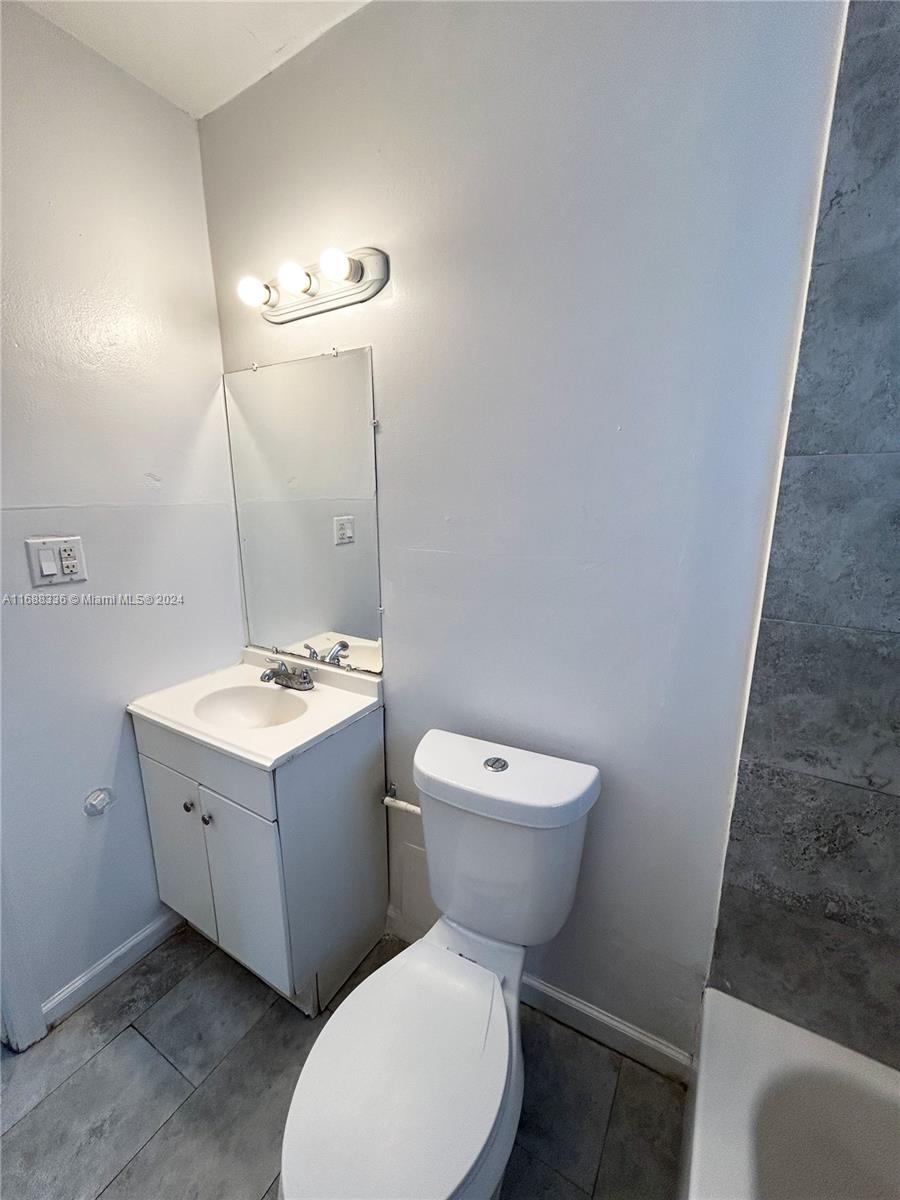 651 Northeast 86th Street, Unit 3 Miami, FL 33138 - Photo 8 of 11 a bathroom with a toilet sink and mirror