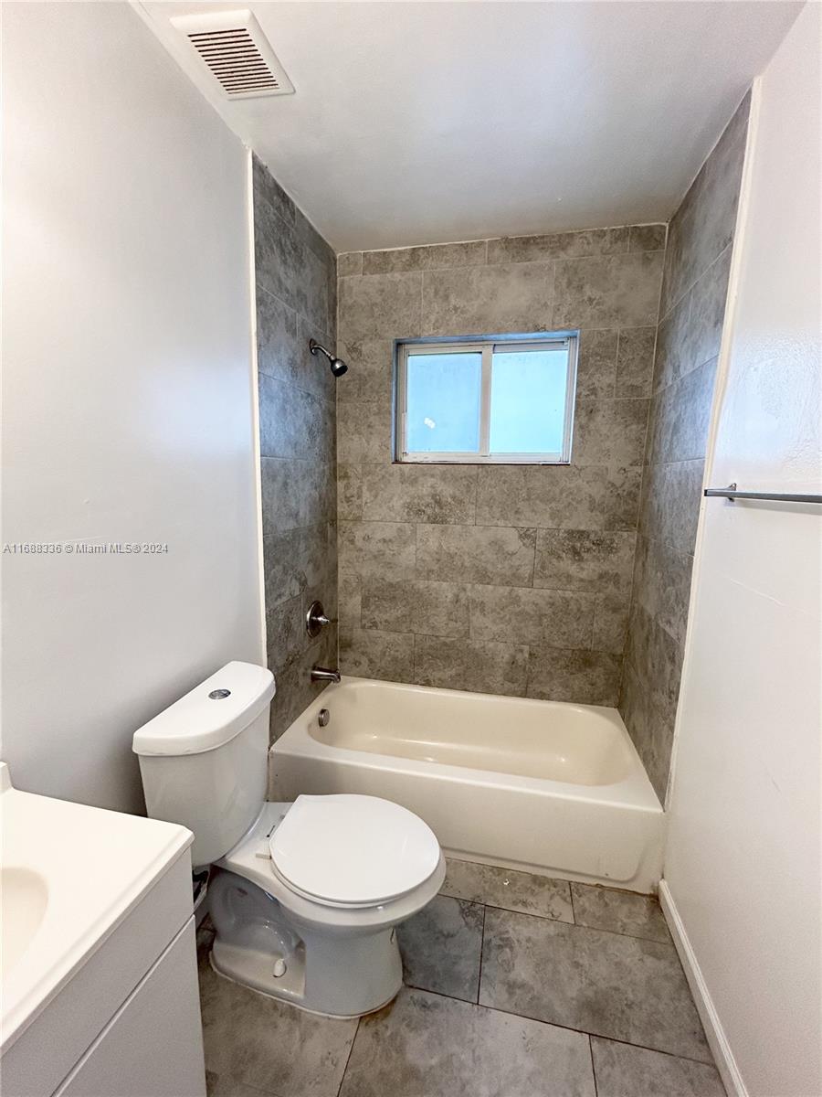 651 Northeast 86th Street, Unit 3 Miami, FL 33138 - Photo 9 of 11 a bathroom with a toilet a sink and bathtub