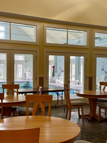 a living room with couches and a dining table with wooden floor