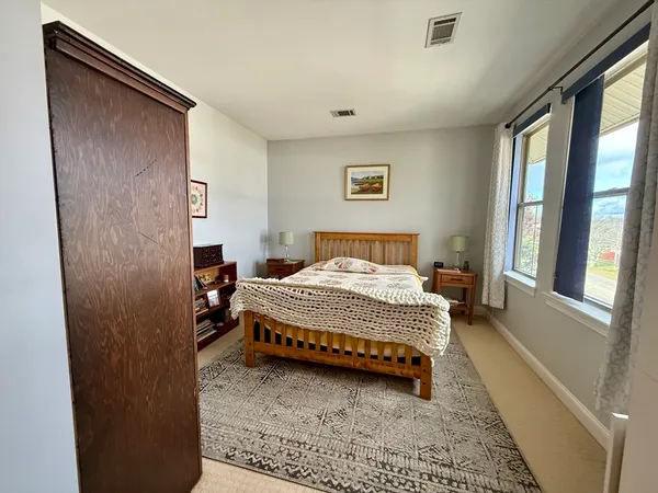a bedroom with a bed and a large window