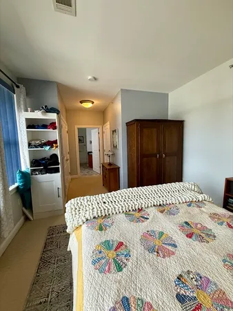a bedroom with a bed and a large mirror on dresser