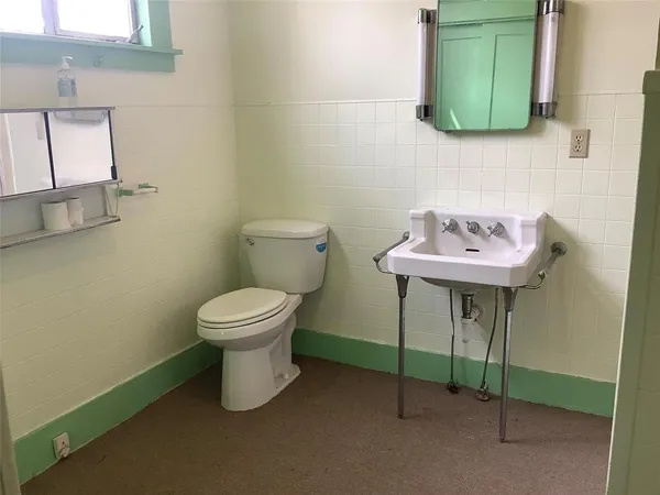 a bathroom with a toilet sink and mirror