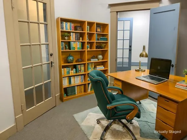 a view of a workspace with furniture and a bookshelf