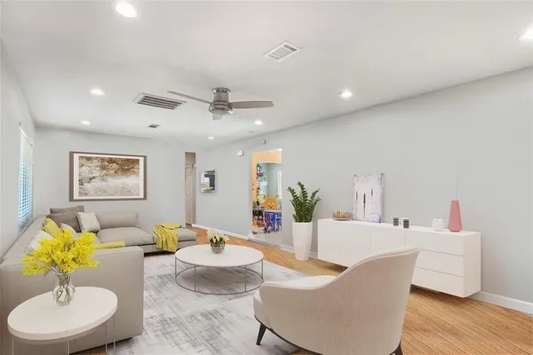 a living room with furniture and a wooden floor