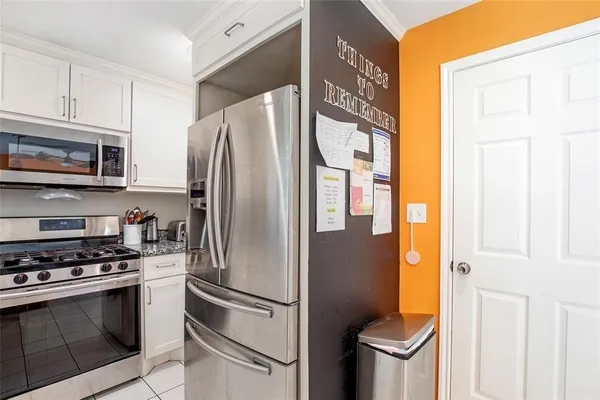 a kitchen with stainless steel appliances granite countertop a refrigerator a stove and a sink with cabinets