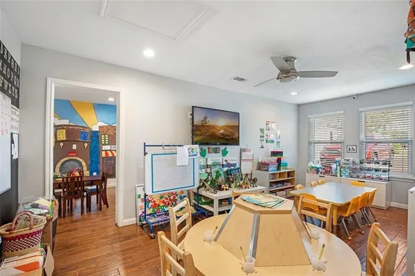 a living room with furniture a flat screen tv and kitchen view
