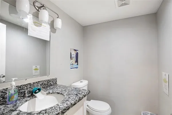 a bathroom with a granite countertop sink and a mirror