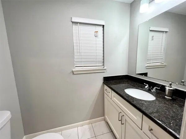 a bathroom with a granite countertop sink and a vanity