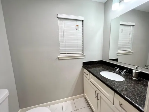 a bathroom with a granite countertop sink and a vanity
