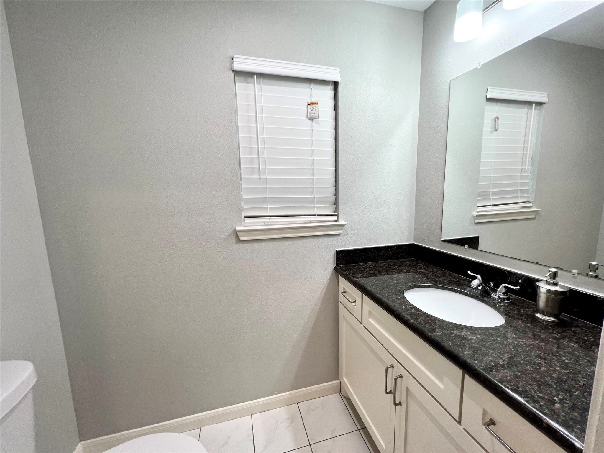 5302 Treaschwig Road Spring, TX 77373 - Photo 10 of 41 a bathroom with a granite countertop sink and a vanity