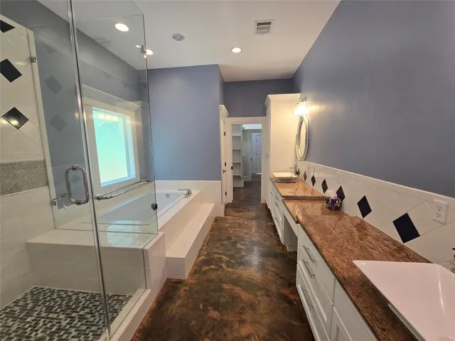a bathroom with a tub sink and mirror