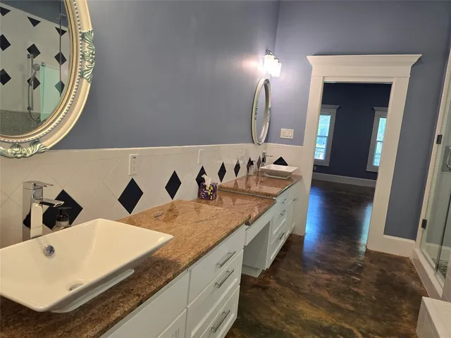 a bathroom with a granite countertop sink and a mirror