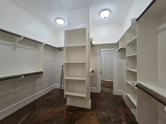 a view of walk in closet with empty racks