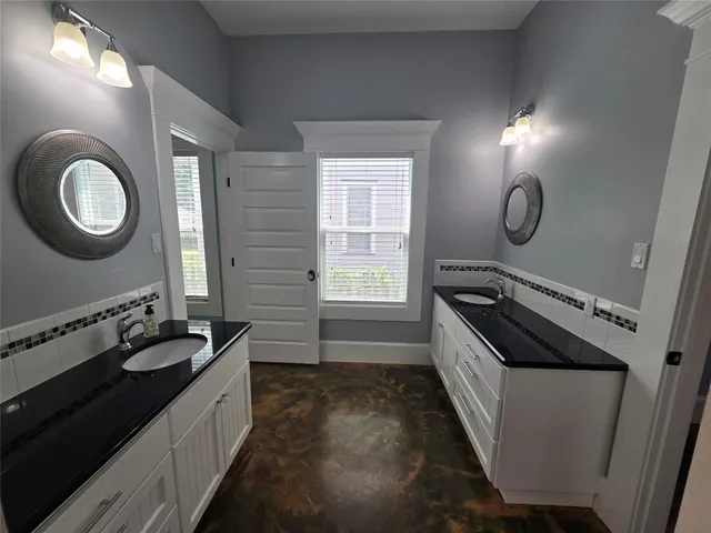 a bathroom with a double vanity sink and a mirror