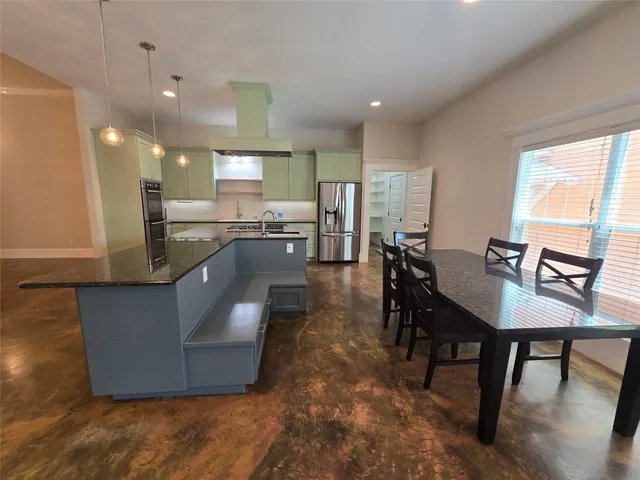 a living room with couches chairs and a dining table with kitchen view