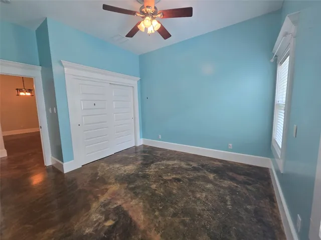 an empty room with closet and fan