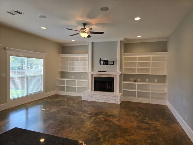 a view of a livingroom with a fireplace cabinet and windows