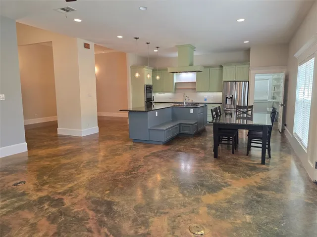 a living room with couches and kitchen view with wooden floor