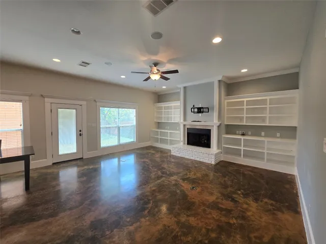a view of an empty room with a fireplace and a window