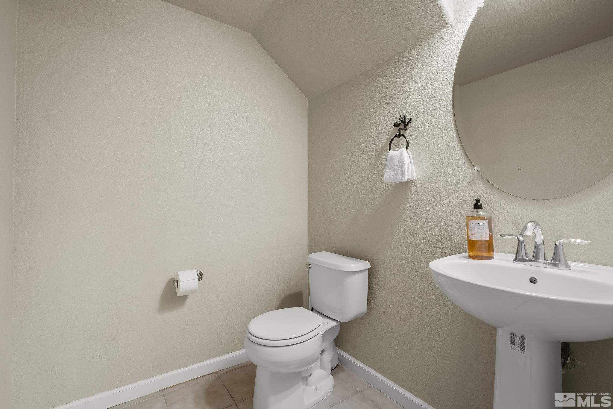 1925 Wind Ranch Road, Unit A Reno, NV 89521 - Photo 12 of 21 a bathroom with a sink a toilet and a mirror