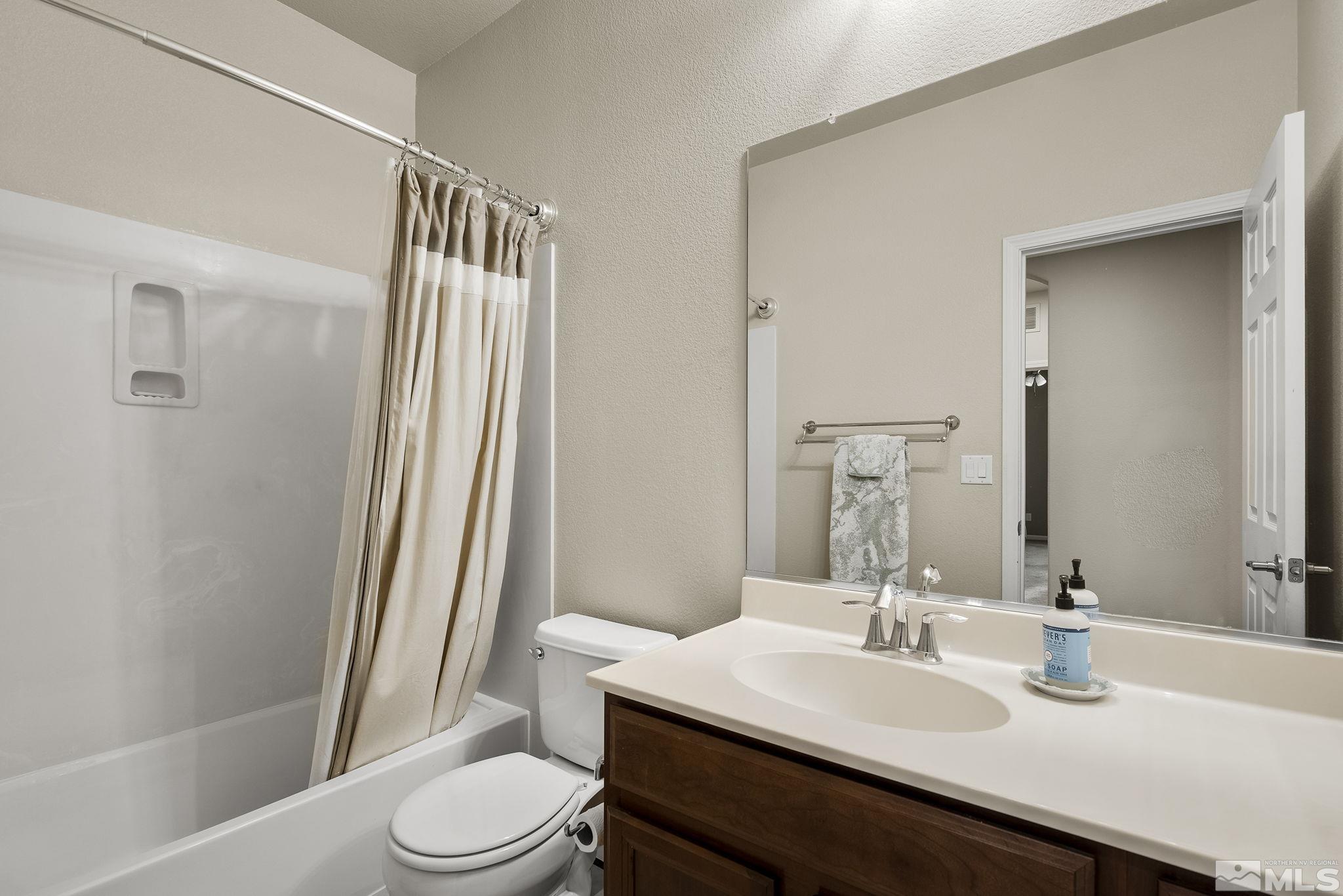1925 Wind Ranch Road, Unit A Reno, NV 89521 - Photo 17 of 21 a bathroom with a sink a toilet a mirror and shower