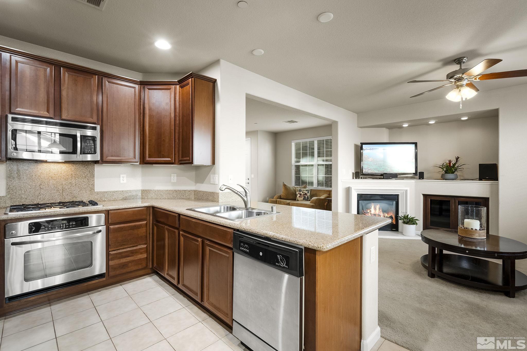 1925 Wind Ranch Road, Unit A Reno, NV 89521 - Photo 10 of 21 a kitchen with stainless steel appliances granite countertop a sink and stove top oven