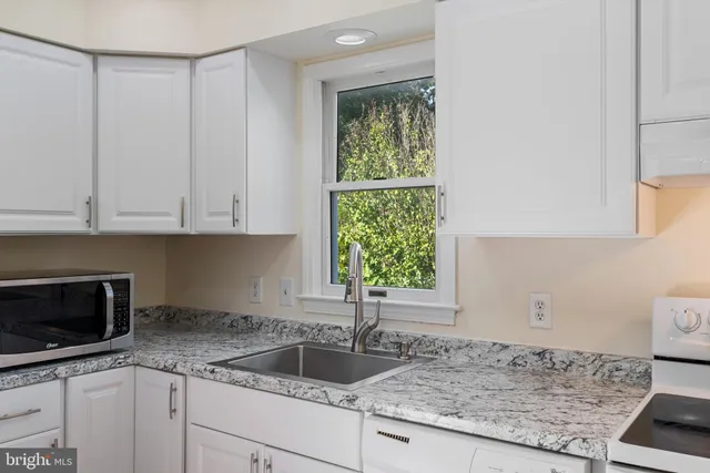a kitchen with granite countertop a sink and a stove