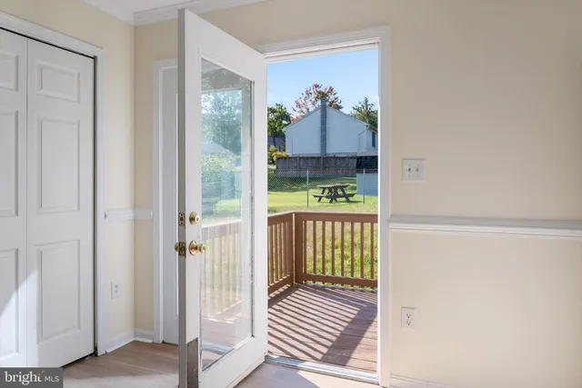 a view of a hallway with wooden floor and door