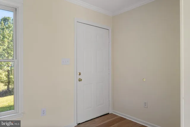 a view of a small space with wooden floor and a window