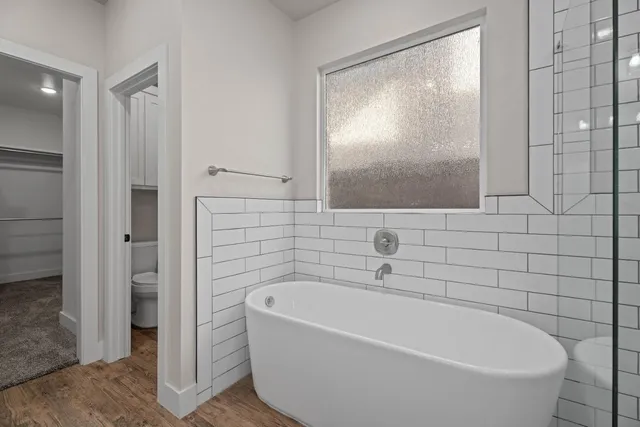 a white bath tub sitting next to a white sink and vanity