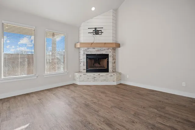 a living room with a fireplace and wooden floor